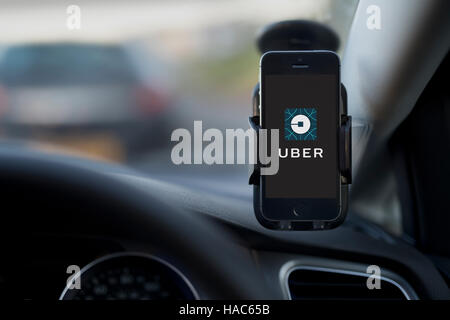 L'intérieur d'un Uber taxi avec un iPhone sur le pare-brise de la voiture avec le logo de l'entreprise. Banque D'Images