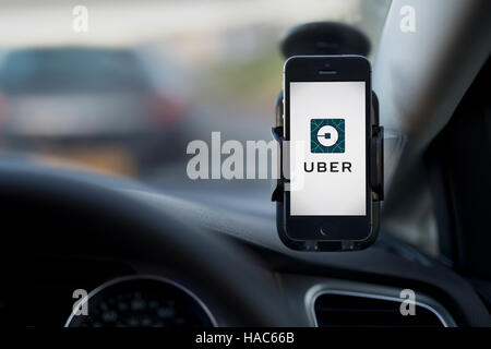 L'intérieur d'un Uber taxi avec un iPhone sur le pare-brise de la voiture avec le logo de l'entreprise. Banque D'Images