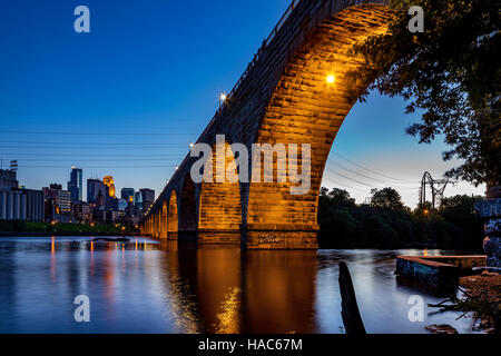 Une superbe vue sur le pont en arc de pierre de Minneapolis, MN, USA, au crépuscule, en montrant une partie de la ville Banque D'Images