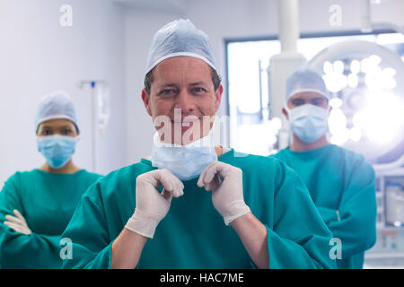 Équipe de chirurgiens portant un masque chirurgical en salle d'opération Banque D'Images