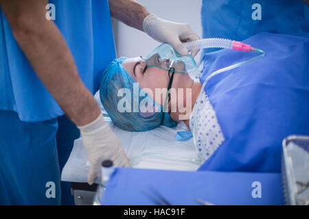 Surgeon putting oxygen mask on a patient Banque D'Images