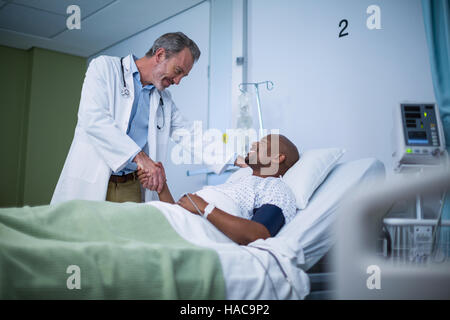 Happy doctor and patient shaking hand dans Ward Banque D'Images