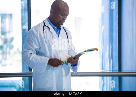 Médecin homme lire les rapports dans le couloir Banque D'Images