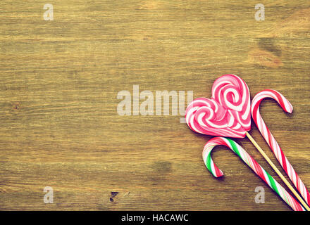 Sucette en forme de cœur et des bonbons sur un fond de bois de style vintage.Place pour le texte. Vue d'en haut Banque D'Images