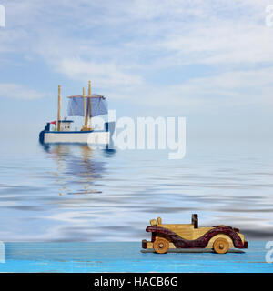 Petite voiture sur une surface en bois bleu et toy voilier en mer Banque D'Images