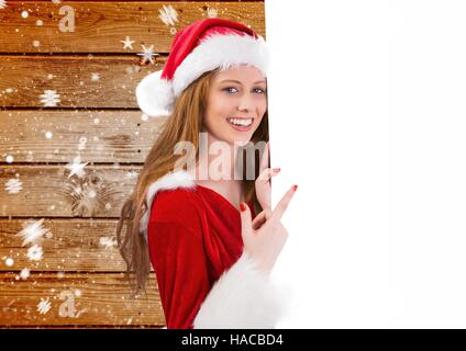 Belle femme à santa costume pointing at placard Banque D'Images