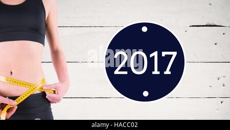 Mid section of woman measuring her waist contre 2017 Banque D'Images