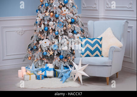 Maison de Noël intérieur - un fauteuil confortable et de sapin décoré en bleu blanc Banque D'Images