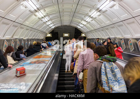 Les banlieusards d'occupation sur les escaliers mécaniques d'une station de métro à Londres, Royaume-Uni Banque D'Images