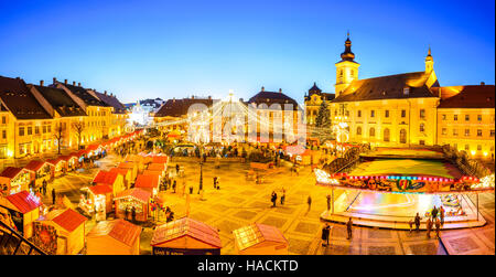 Sibiu, Roumanie. Nuit libre avec des touristes à Marché de Noël en grand marché de la ville médiévale de Sibiu, Transylvanie monument. Banque D'Images