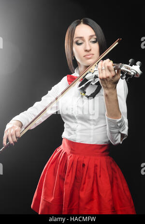 Belle femme joue du violon sur un fond noir Banque D'Images