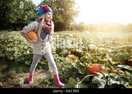 Petite fille à la citrouille dans le domaine Banque D'Images