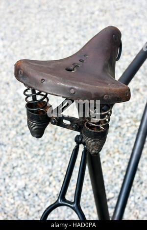 Ancienne selle en cuir brun sur le vieux vélo noir Banque D'Images