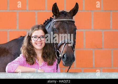 Cheval de Hanovre. Femme debout à côté de jument baie. Allemagne Banque D'Images