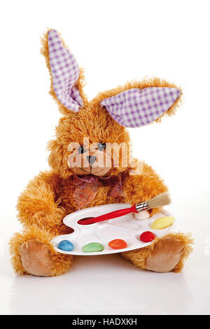 Doudou lapin de Pâques avec une palette de couleurs faite d'œufs de pâques et pinceau peinture Banque D'Images
