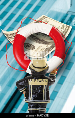 Fireman holding une bouée avec US dollar billets/greenbacks en face d'une banque, bâtiment symbolique de la crise bancaire Banque D'Images