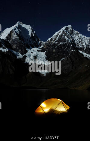 Brillant tente dans l'obscurité à Laguna Carhuacocha, Yerupacha Yerupacha, gauche, et Chico, derrière, Cordillera Huayhuash, Pérou Banque D'Images