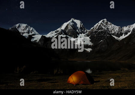 Brillant tente dans l'obscurité à Laguna Carhuacocha, de gauche, Siula Grande, Yerupacha Yerupacha, Chico derrière, Cordillera Huayhuash Banque D'Images