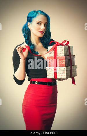 Image de style vintage woman holding pile de cadeaux de Noël à égalité avec ruban rouge Banque D'Images