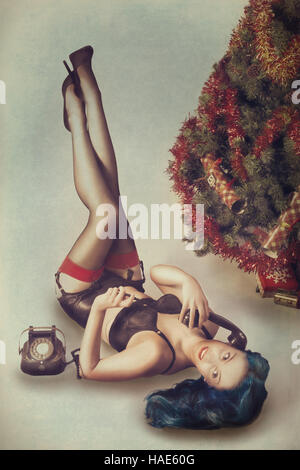 Carte postale vintage pin up style de femme à Noël sur téléphone Banque D'Images