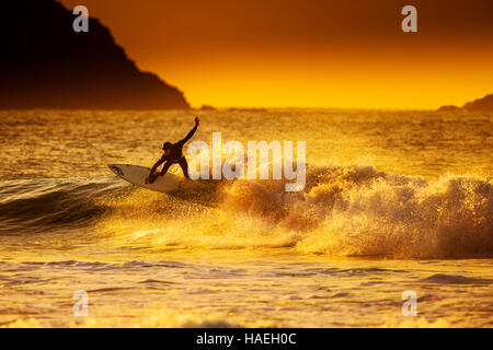 Au cours de surf un spectaculaire coucher du soleil doré à dans Fistral Newquay, Cornwall. UK. Banque D'Images