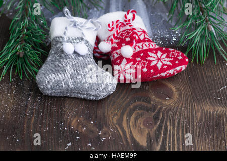 Composition de Noël chaussettes tricotées et deux branches d'arbre de Noël sur fond de bois Banque D'Images