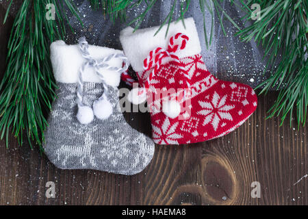 Composition de Noël chaussettes tricotées et deux branches d'arbre de Noël sur fond de bois Banque D'Images