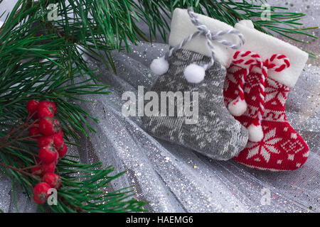 Composition de Noël chaussettes tricotées, deux baies rowan rouge et des branches d'arbre de Noël Banque D'Images