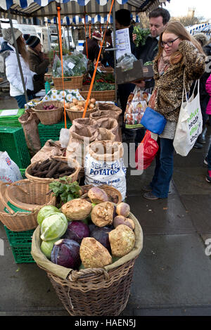 Les clients à la recherche de l'agriculture biologique en vente à l'étude du marché hebdomadaire à Édimbourg, Écosse, Royaume-Uni. Banque D'Images