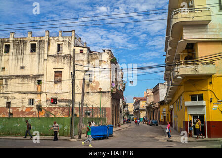 Havana Street corner view apartment block et rue avec mur vert de terrain de sport surmonté d'un grillage de sécurité dans le centre de La Havane Banque D'Images