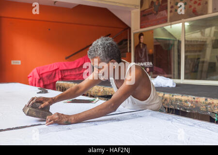 Un homme à l'aide d'un bloc traditionnel méthode d'impression sur une feuille de coton, Jaipur, Inde Banque D'Images