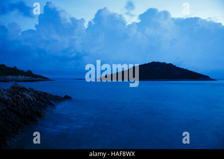 Déménagement tempête dans plus de Veli Osir Island à l'aube, vu de Zaosiri Beach, sur l'île de Losinj Mali Losinj, Croatie. Banque D'Images