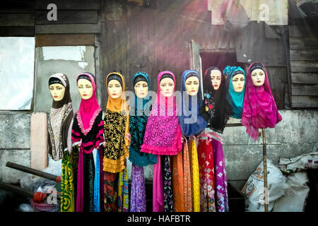 Rangée de mannequins affichant des robes colorées dans le marché de rue de Jakarta, en Indonésie. Banque D'Images