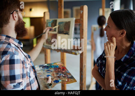 Enseignant à la peinture à la maturité de l'un de ses étudiants en art-studio Banque D'Images