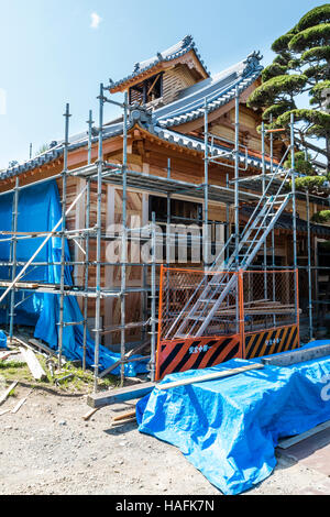 Le Japon, Tatsuno. Site de construction dans la nouvelle construction, de maison typiquement japonais avec bois. Les échafaudages autour du bâtiment, avec des draps bleus. Banque D'Images