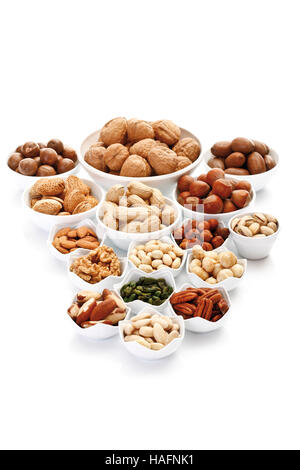 Un assortiment de noix et amandes dans des bols en céramique, pacanes, noix, noisettes, noix de macadamia, cacahuètes, amandes, pistaches Banque D'Images