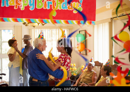 Groupe de vieux amis et famille célébrant senior man anniversaire en maison de retraite. Heureux les personnes âgées s'amusant au cours de partie en hospice. Banque D'Images