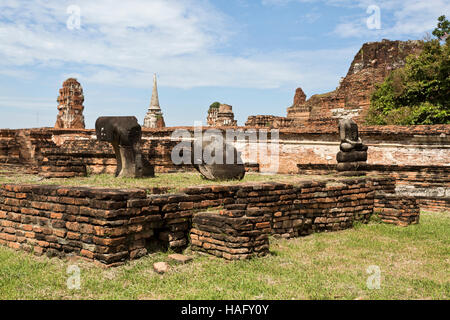 Ruines du temple de briques rouges de Wat Mahathat, le Temple de la grande relique, et les restes de quelques statues de Bouddha sans tête, à Ayutthaya, Thaïlande Banque D'Images