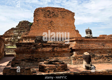 Ruines du temple de briques rouges de Wat Mahathat, le Temple de la grande relique, et les restes de quelques statues de Bouddha sans tête, à Ayutthaya, Thaïlande Banque D'Images