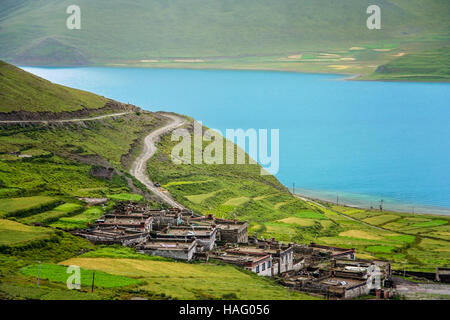 Maison traditionnelle tibétaine sur la pente de la colline sur la rive du magnifique Lac Yamdrok Tso Lake dans le Tibet central, la Chine. Banque D'Images