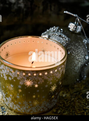 Libre d'une bougie allumée dans un pot en verre décoré et une salle de bal de Noël Banque D'Images