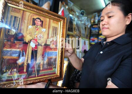 Bangkok, Thaïlande. 30Th Nov, 2016. Un membre du personnel d'une boutique de souvenirs démontre un portrait du Prince Maha Vajiralongkorn à vendre à Bangkok, Thaïlande, le 30 novembre 2016. Le parlement thaïlandais a déclaré mardi que le Prince Maha Vajiralongkorn est de devenir le roi de Thaïlande au cours d'une réunion télévisée. À Bangkok, certains magasins ont commencé à vendre des portraits du prince même avant son accession au trône. © Sageamsak Rachen/Xinhua/Alamy Live News Banque D'Images