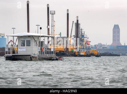 Wismar, Allemagne. 30Th Nov, 2016. La plate-forme de travail de l'équipe d'archéologie maritime flotte à côté de navires à la recherche de lieux de la cité médiévale d'épaves dans le port de Wismar, Allemagne, 30 novembre 2016. Les archéologues ont commencé à découvrir deux épaves médiévales de la mer baltique, accompagné par temps orageux. Les navires ont été remonte à la 13e et 14e siècle par l'analyse des fragments de bois récupéré. Photo : Jens Büttner/dpa-Zentralbild/dpa/Alamy Live News Banque D'Images