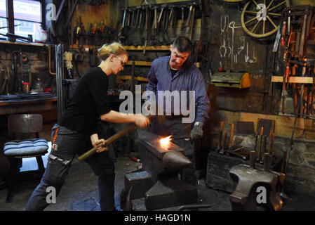 Le forgeron et tôlier Wolf-Dieter Wittig exécute le plus ancien encore en fonctionnement en Allemagne, la forge forge Krellsche à Wernigerode, Allemagne, 14 novembre 2016. Wittig et son apprenti Meta Alinde travailler sur un cœur de fer, le 19-year-old veut apprendre le métier d'un metallworker dans un délai de trois ans. Elle espère se spécialisent dans metall design. Wittig Wolf-Dieter est la 5ème génération de la famille qui travaillent dans la forge, qui existe depuis 1678. Il est le seul organisme de formation pour cette rare commerce dans tout le land de Saxe-Anhalt. Banque D'Images