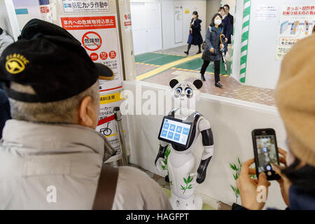 Tokyo, Japon. 1er décembre 2016. Les gens prennent des photos de robot humanoïde de SoftBank Pepper caractérisé comme un panda sur son premier jour en tant que nouveau membre du personnel pour la ligne de métro Ginza à Ueno Station le 1 décembre 2016, Tokyo, Japon. Le poivre est programmé pour interagir avec les usagers japonais et étrangers dans sept langues différentes et s'efforcera d'introduire l'information par métro de Tokyo jusqu'au 31 mars 2017. Credit : Rodrigo Reyes Marin/AFLO/Alamy Live News Banque D'Images