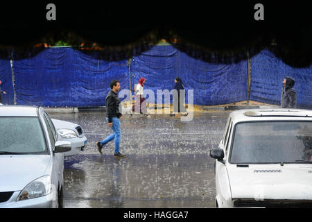 Le Caire, Égypte. Dec 12, 2015. Les Egyptiens à pied à la rue sous la pluie et une vague de froid sur plus de pays et la capitale du Caire (Égypte) le 1 décembre 2016 © Amr Sayed/APA/Images/fil ZUMA Alamy Live News Banque D'Images