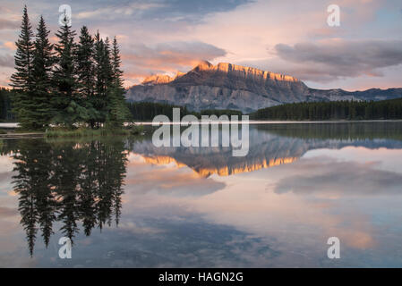 Le soleil embrasse le haut des montagnes rocheuses surplombant le lac Two Jack au Canada Banque D'Images