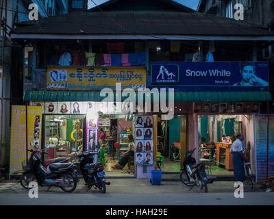 Deux salons de beauté la nuit à Sittwe, capitale de l'État de Rakhine au Myanmar. Banque D'Images