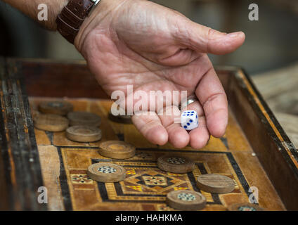 L'antique jeu de backgammon. L'homme jette des dés. Banque D'Images