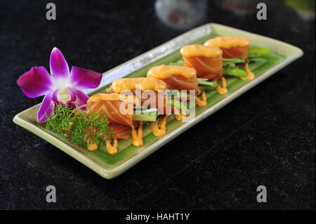 Rouleaux de saumon avec de la mayonnaise sur le plateau Banque D'Images